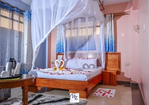 Kisii的住宿－Hotel Zesper，一间卧室配有一张带天蓬的床