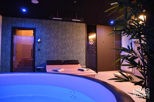 a room with a bath tub with a bed in it at Hors du Temps in Aywaille
