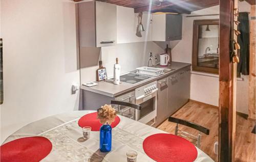małą kuchnię ze stołem i czerwonymi krzesłami w obiekcie Cozy Home In Stara Dobrzyca With Wifi w mieście Rusinowo