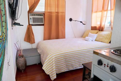 een kleine slaapkamer met een bed en een raam bij Migue´s Tiny Miami Alcove in Miami