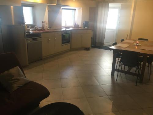 Il comprend une cuisine avec une table, un canapé et une table. dans l'établissement Petite maison de campagne, à Recey-sur-Ource