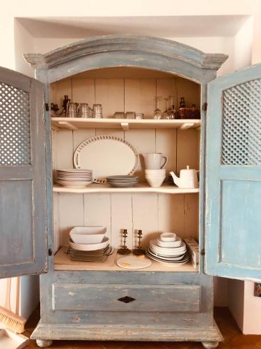 an old blue cabinet with plates and dishes in it at Herdade de Alagães in Mértola