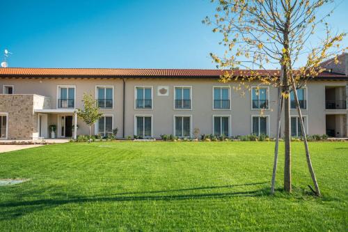 a building with a green lawn in front of it at Agriturismo Maria Vittoria in Custoza