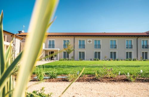 a building with a lawn in front of it at Agriturismo Maria Vittoria in Custoza
