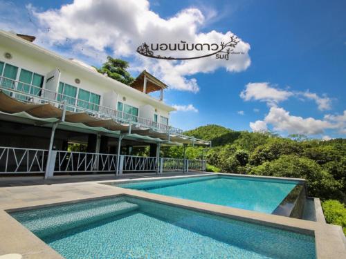 a resort with a swimming pool in front of a building at Norn Nab Dao RimPhu Resort in Chiang Khan