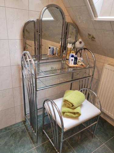 La salle de bains est pourvue de 2 chaises et d'un miroir. dans l'établissement Lilly & Fine, à Zingst