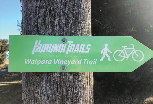 a sign on a tree with a bike on it at Cosy Cottage in the Vines in Waipara