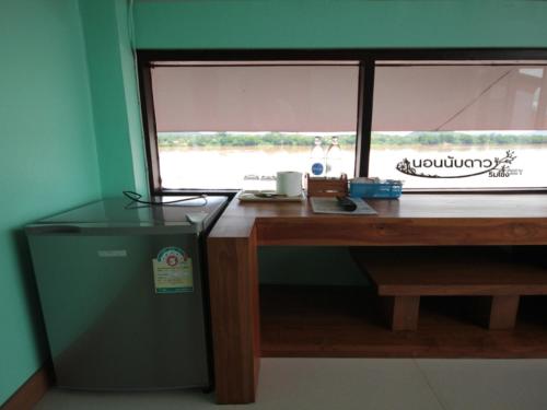 a desk with a window and a trash can at Norn Nab Dao Rimkhong in Chiang Khan