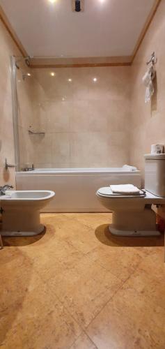 a bathroom with a tub and a toilet and a sink at Locanda Ca' del Brocchi in Venice
