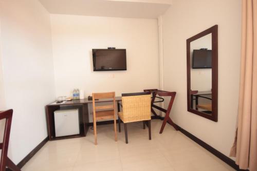 a dining room with a table and a mirror at Norn Nab Dao Rimkhong in Chiang Khan