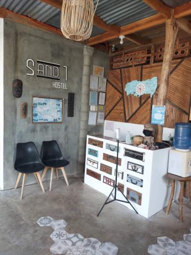 a room with two black chairs and a white cabinet at Sand 1 Hostel in Siquijor
