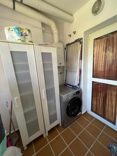 MI CAPRICHO, Beach Front Apartment P.14 3ºB في ميخاس كوستا: غرفة غسيل مع غسالة ملابس وغسالة ملابس
