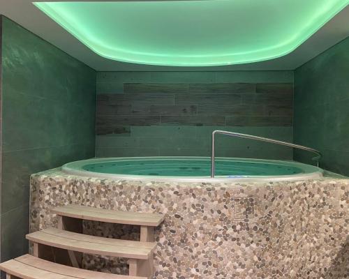 a large bath tub with a green ceiling at Ovruč Apartments Štrbské Pleso in Štrbské Pleso