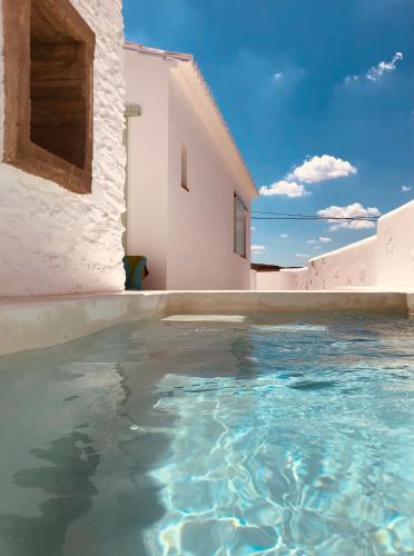 a pool of water in front of a white building at Herdade de Alagães in Mértola