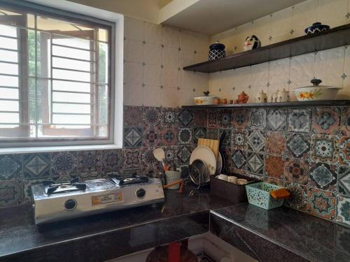 a kitchen with a sink and a stove in it at A Chettinad villa in Coimbatore on the way to Adiyogi and nearer to Maruthamalai in Coimbatore