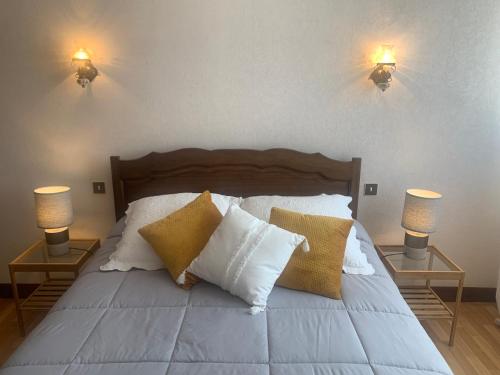 a bedroom with a bed with pillows and two lamps at A louer appartement dans une maison in Arcangues