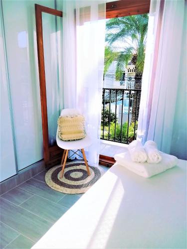 a bedroom with a bed and a chair and a window at Casa Ilda (Gran Alacant) in Gran Alacant