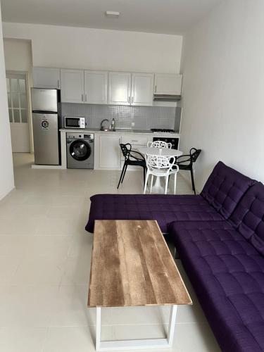 a living room with a purple couch and a table at Super appartement central avec patio. in Santa Maria