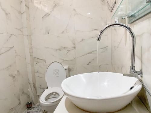 a white bathroom with a sink and a toilet at Lekjon Cottage in Tuktuk Siadong