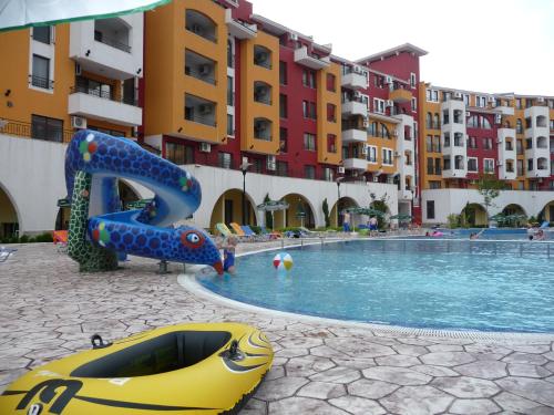 a swimming pool with a slide in front of some buildings at STUDIO DELUXE IN MARINA CAPE 4 stars complex 33 7 in Aheloy