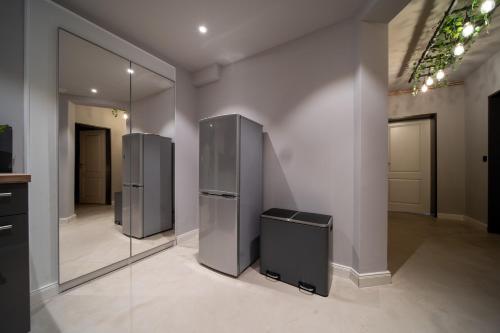 two stainless steel refrigerators in a room with mirrors at La Bodega - Designer Apartment an der Alster in Hamburg