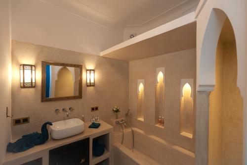 bagno con lavandino e specchio di Riad Mylaya a Marrakech