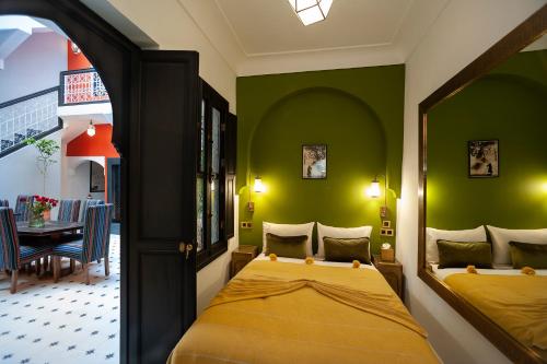 um quarto com uma cama num quarto com paredes verdes em Riad Mylaya em Marrakech