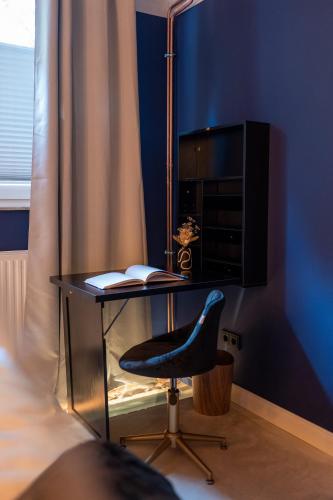 a desk with a monitor and a chair next to a bed at La Bodega - Designer Apartment an der Alster in Hamburg