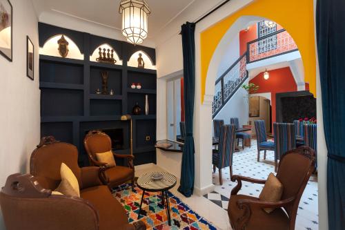 een woonkamer met stoelen en een open haard bij Riad Mylaya in Marrakesh