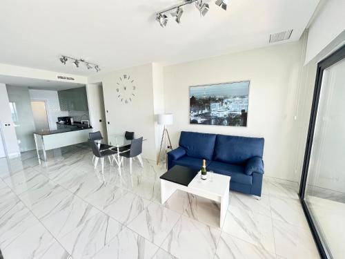 a living room with a blue couch and a table at Sunset Drive Resort & Spa in Benidorm