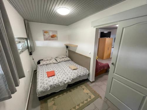 Habitación pequeña con cama y puerta en Iker Nyaraló Balatonfenyves, en Balatonfenyves