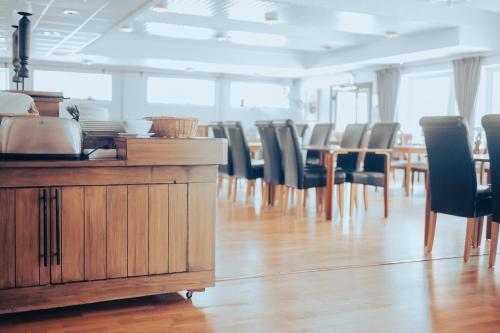 a dining room with chairs and tables in a room at Nadden Hotell & Konferens in Ramnäs