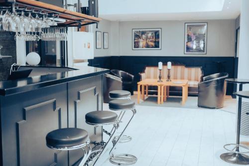 a kitchen with bar stools and a dining room with a table at Nadden Hotell & Konferens in Ramnäs