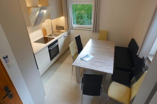 een kleine keuken met een houten tafel en stoelen bij Loisachglück in Garmisch-Partenkirchen