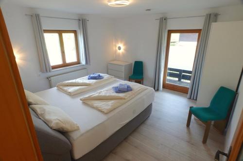 1 dormitorio con 2 camas y silla verde en Loisachglück, en Garmisch-Partenkirchen