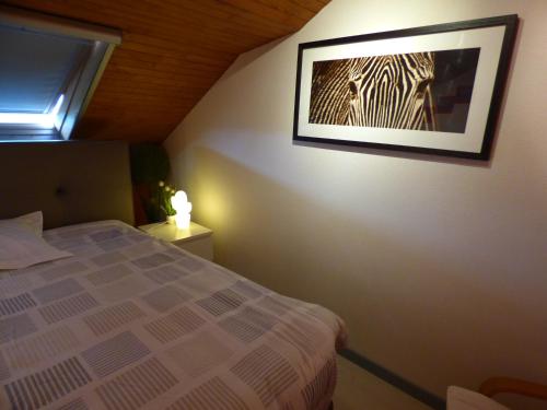 a bedroom with a bed and a picture on the wall at B&B Le Jardin d'Epicure in Olne