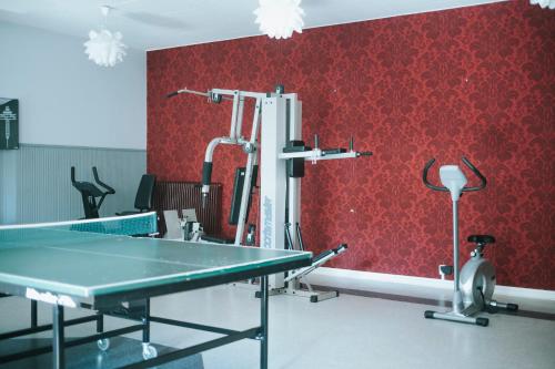 a ping pong table in front of a red wall at Nadden Hotell & Konferens in Ramnäs