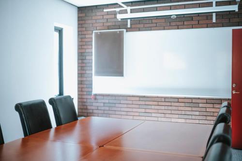 a conference room with a wooden table and chairs at Nadden Hotell & Konferens in Ramnäs