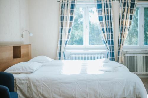 a white bed in a bedroom with a window at Nadden Hotell & Konferens in Ramnäs