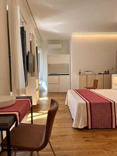 a hotel room with two beds and a table and a chair at Dimora Elle in La Maddalena