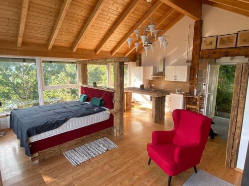 ein Schlafzimmer mit einem Bett und einem roten Stuhl in der Unterkunft Atelier mit Bergblick 
