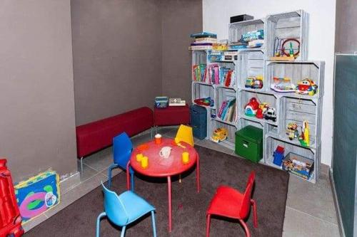 een kamer met een tafel en stoelen en een speelkamer bij Edelweis in Blankenberge