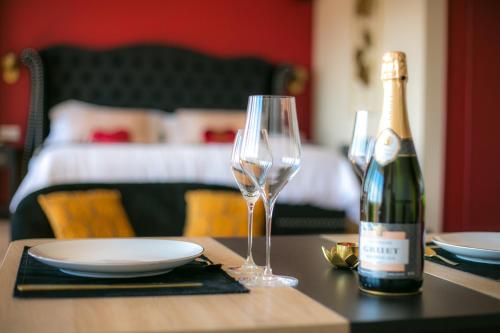 - une bouteille de vin et un verre de vin sur une table dans l'établissement Le Boudoir de Fanny - Sauna/Balnéo/ciné/Hamacs, au Havre