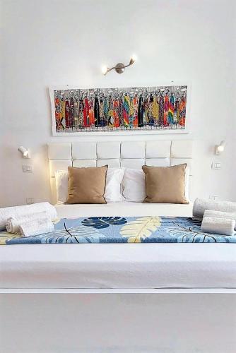 a bedroom with a bed with a painting on the wall at Branco Suites - Rooms & Holiday Apartments in Santa Maria