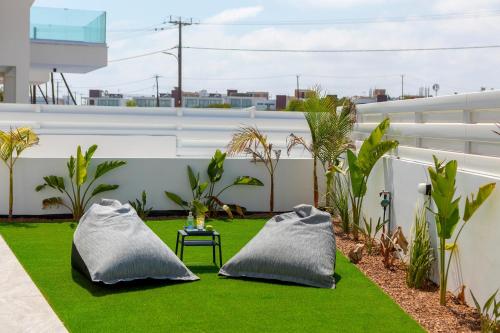 a patio with two pillows on the grass at Protaras Sol e Mar Villa 3 in Protaras