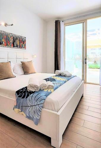 a large white bed in a room with a window at Branco Suites - Rooms & Holiday Apartments in Santa Maria