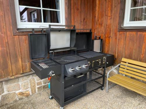 czarny grill siedzący obok budynku w obiekcie Horský penzion VEBROVY BOUDY w mieście Pec pod Sněžkou