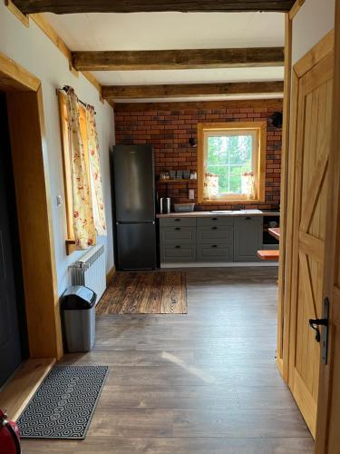 a kitchen with a black refrigerator and a window at Chata Borówkowe Wzgórze in AdamÃ³w