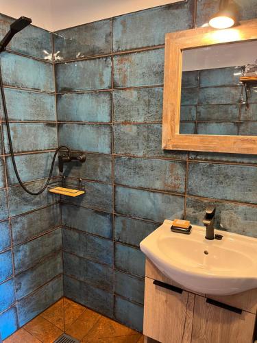 ein Bad mit einem Waschbecken und einem Spiegel in der Unterkunft Chata Borówkowe Wzgórze in AdamÃ³w