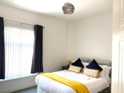 a bedroom with a bed with a yellow blanket at Cosy Cheerful 2 Beds Near Piccadilly, Etihad Stadium Sleeps upto 5 in Manchester